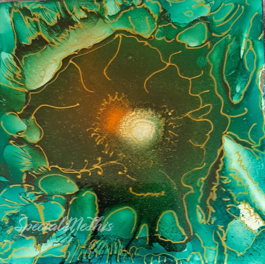 A green and gold Starlight glass tile with a flower on it.