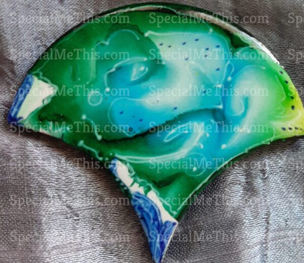 A green and blue Fish Scale Magnets pendant with a blue and green design.