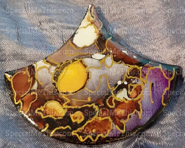 A Fish Scale Magnets with a purple, yellow, and brown design.