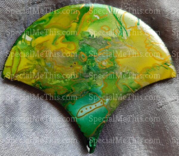 A green and yellow Fish Scale Magnets pendant on a white background.
