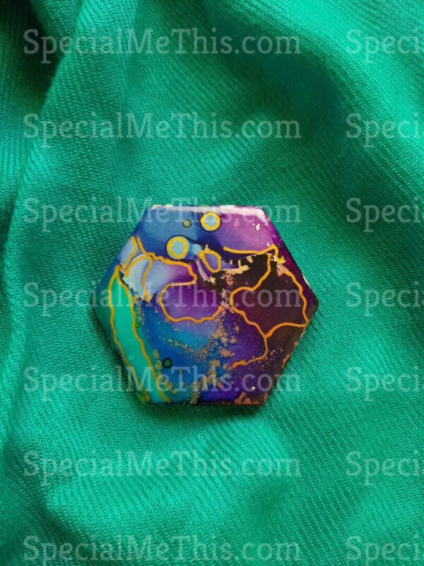 A colorful pin on top of green fabric.
