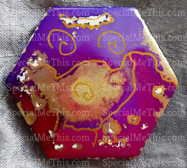 A purple and gold Hexagonal Magnet with a design on it.
