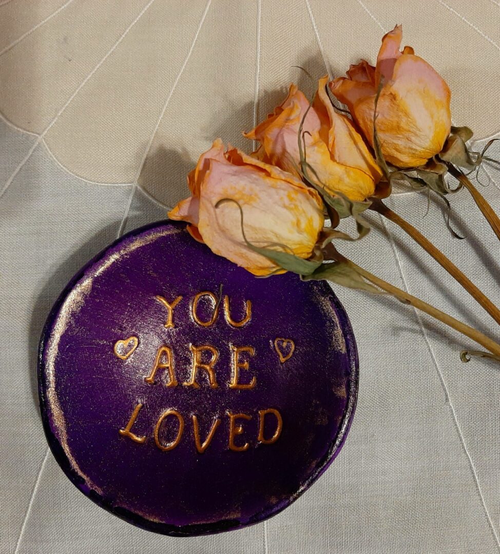 A purple plate with the words " you are loved " on it.